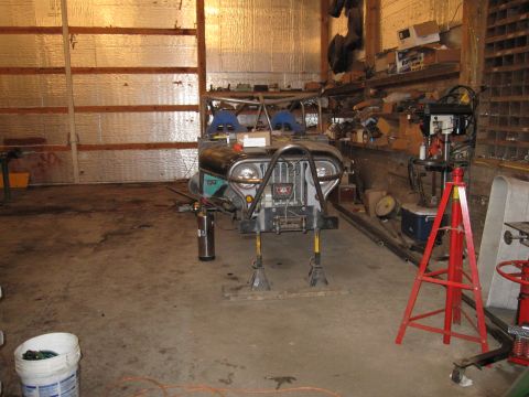 1992 Ford Bronco - Photograph of a stripped vehicle chassis on stands inside a workshop, not a technical document.