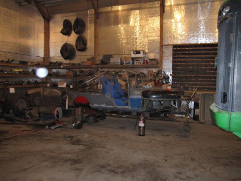 1992 Ford Bronco - Photograph of a vehicle frame and roll cage during a build inside a garage, not a technical document.