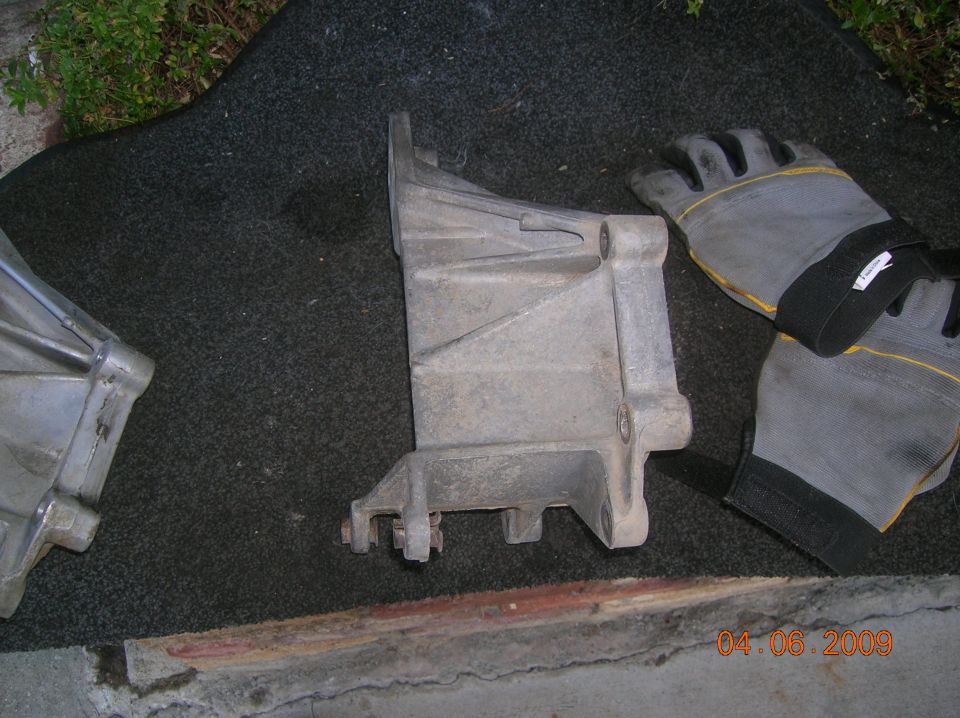 Cast aluminum bracket and gray work gloves on carpet