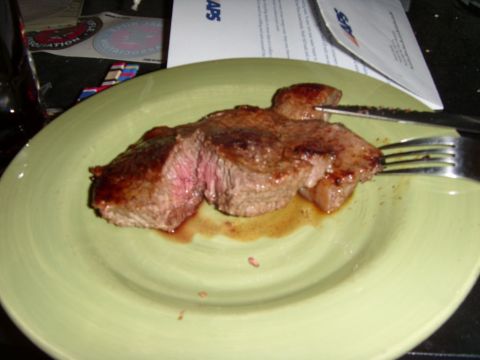 1978 Ford Bronco - A medium-rare steak is served on a light green plate, with a fork and knife positioned to cut into it. The steak is juicy and has a rich br…