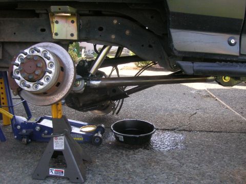 1996 Ford Bronco - The undercarriage of a lifted 1996 Ford Bronco is shown, with the front wheel assembly, brake rotor, and suspension components visible. A h…