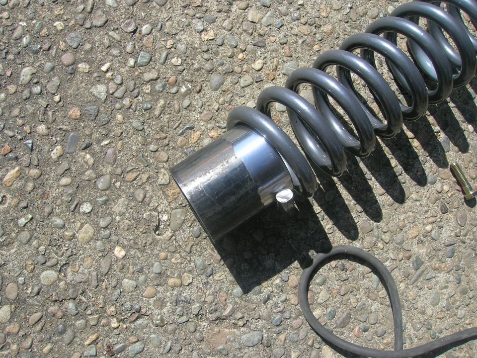 Heavy-duty coil spring with metal sleeve on gravel