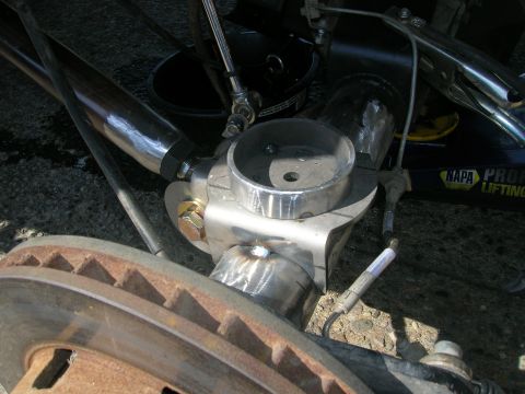 1996 Ford Bronco - A close-up view of a custom suspension component, likely part of a steering or linkage system, attached to a vehicle's brake rotor and spin…