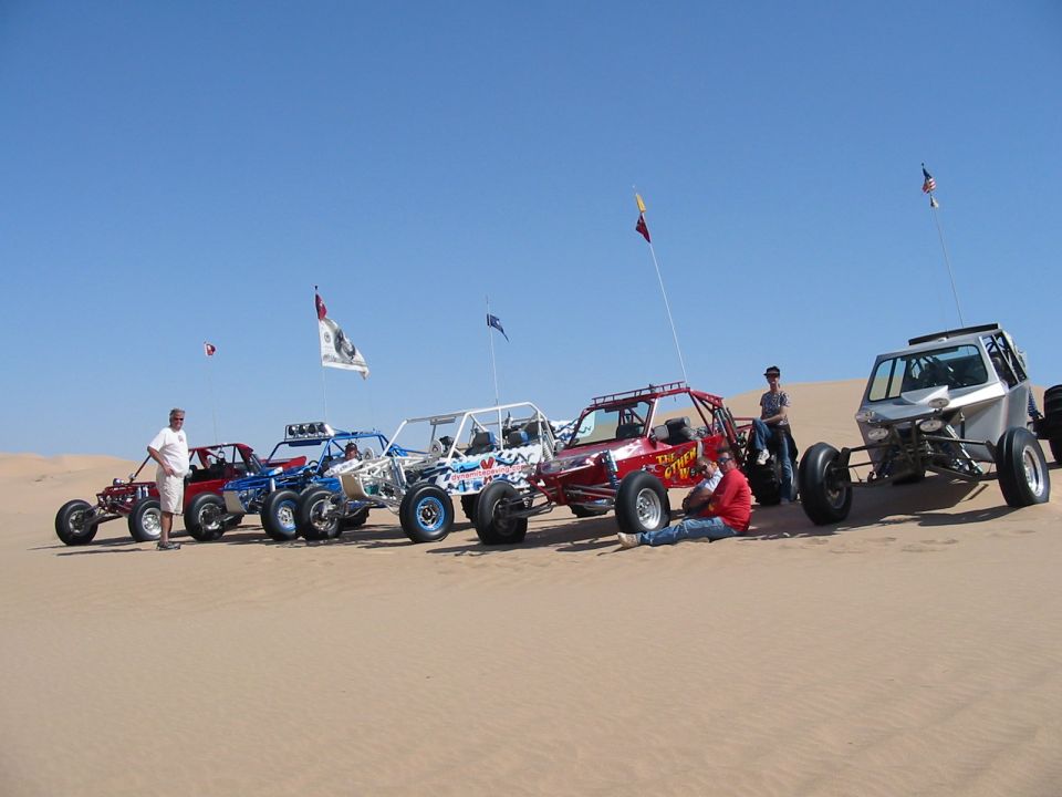 Row of off-road sand rail dune buggies parked on desert dunes