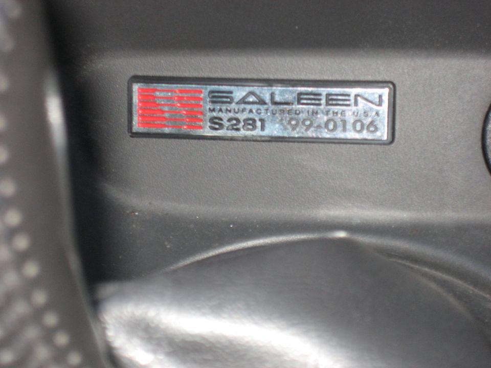 Saleen S281 99-0106 badge on a dark gray surface.
