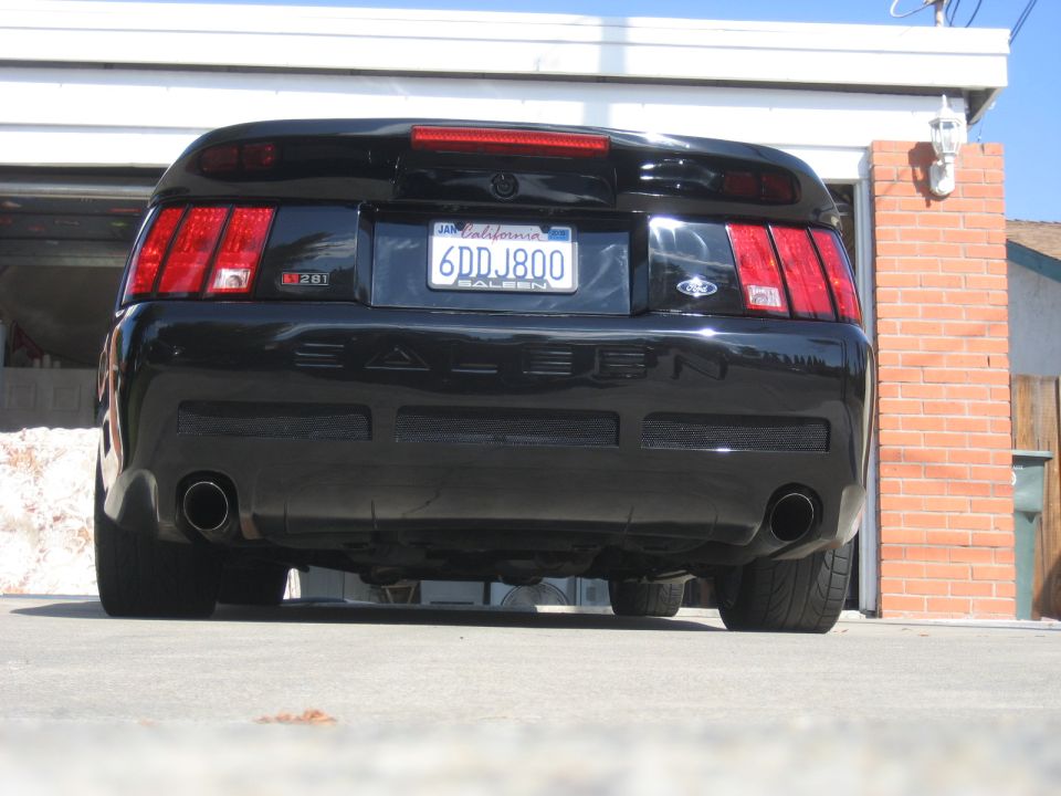 Black Ford Mustang rear view with Saleen badging and custom exhaust.