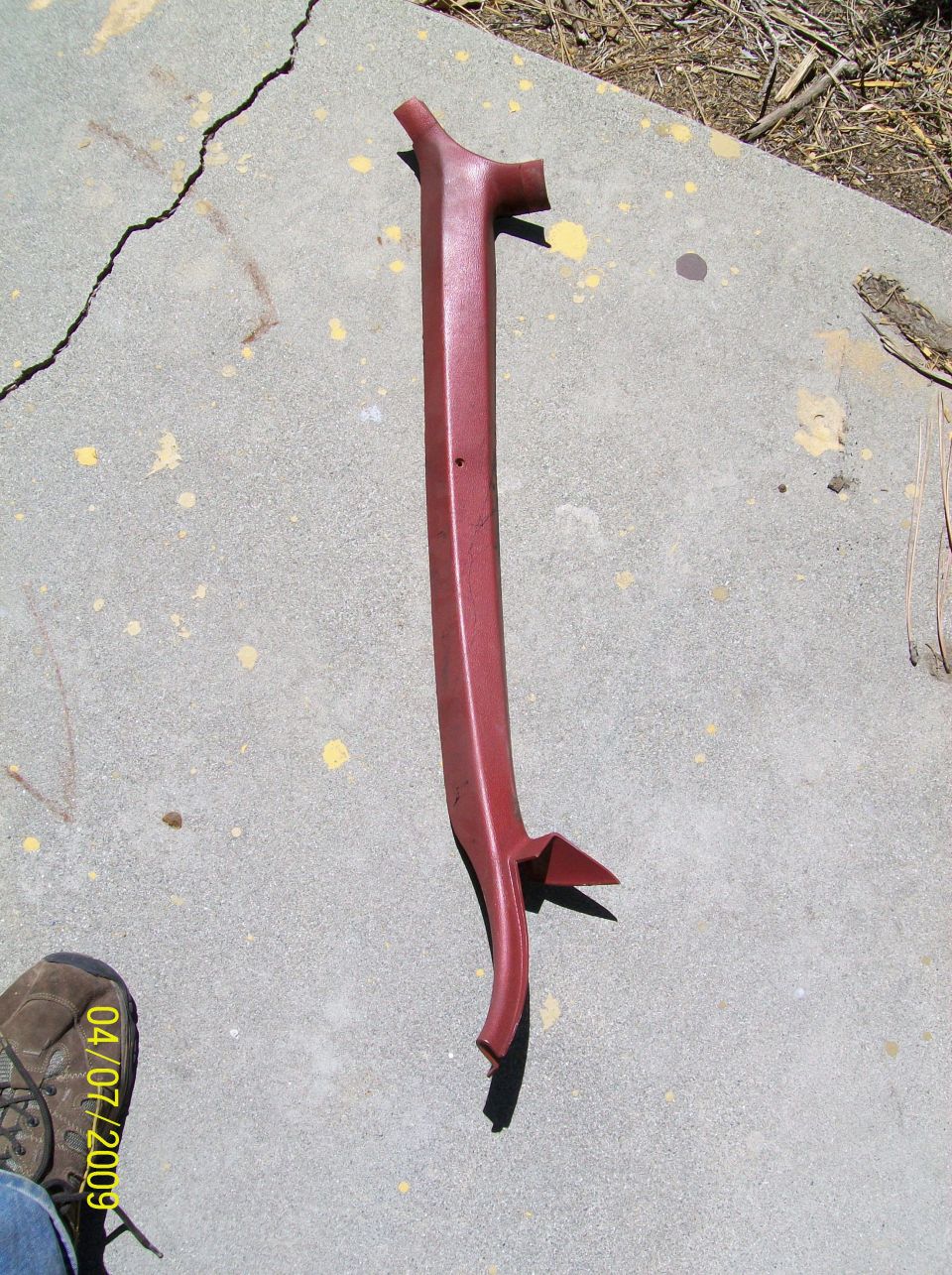 Red plastic car trim piece on concrete