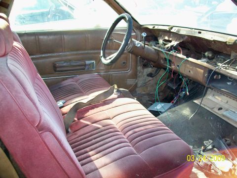 1972 Ford Ranchero - The interior of a classic car, likely a 1972 Ford Ranchero, shows worn maroon velour seats and a disassembled dashboard with exposed wiring…