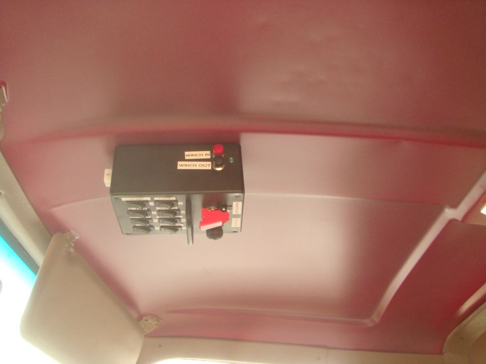 Vehicle interior headliner with a custom winch control panel.