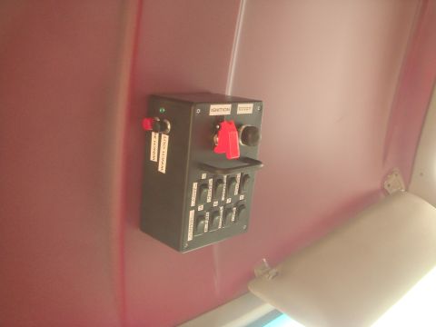 1992 Ford Bronco - A close-up view of a custom switch panel mounted on a red interior surface, featuring labels for winch in/out, ignition, and engine start,…