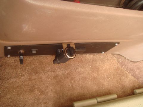 1992 Ford Bronco - A close-up view of a custom-mounted panel with a toggle switch and a cigarette lighter/power outlet, installed on the interior of a vehicle…
