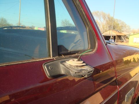 1992 Ford Bronco - Close-up side view of a maroon Ford Bronco showing the driver's side mirror mount and part of the door. A green wire protrudes from the mir…