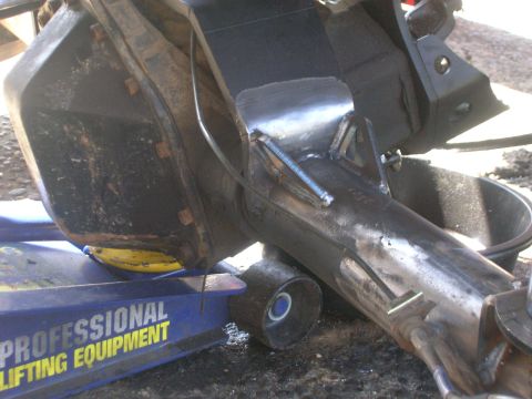 1996 Ford Bronco - A close-up view of a vehicle's rear axle assembly being supported by a blue hydraulic floor jack. The axle is heavily modified with welded…