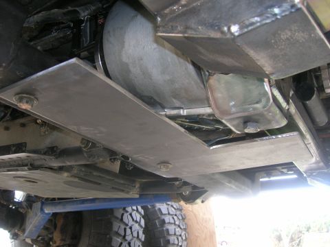 1996 Ford Bronco - Underbody view of a modified 1996 Ford Bronco showing custom metal skid plates protecting the drivetrain components.