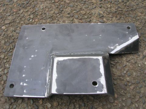 1996 Ford Bronco - A custom-fabricated metal skid plate with multiple mounting holes is shown resting on a gravel surface. The plate features welded sections…