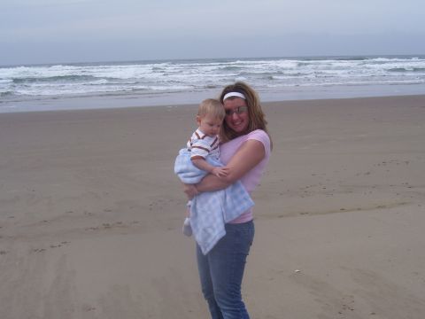 1991 Ford Bronco - Woman and baby enjoy a day at the beach with ocean waves behind them.