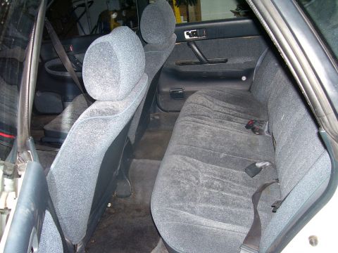 1991 Ford Bronco - The interior of a car shows the rear seats and door panel, with gray fabric upholstery.