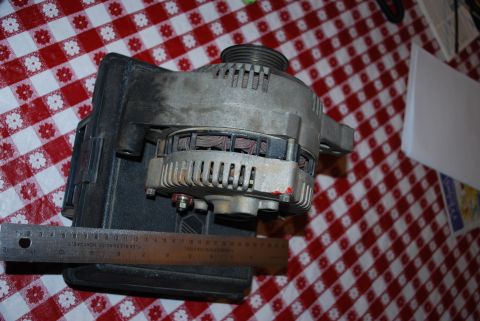 1996 Ford Bronco - An alternator is shown with a ruler for scale on a checkered tablecloth.