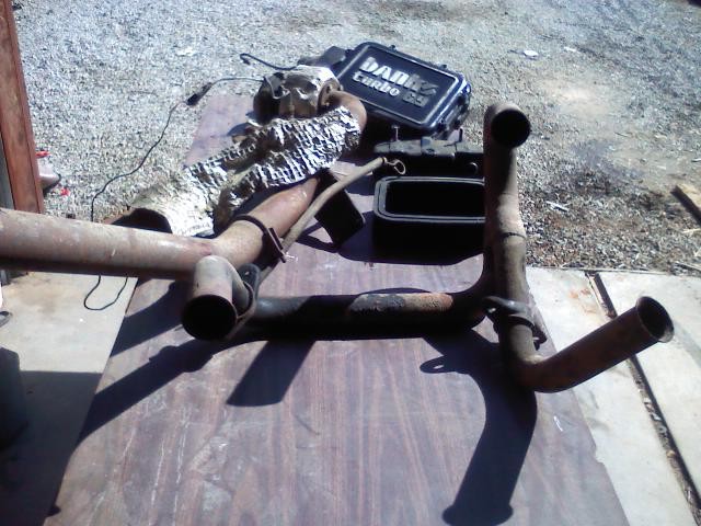 Exhaust pipes and turbocharger parts on a wooden surface
