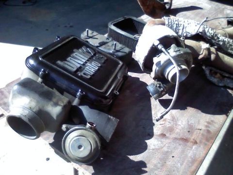 1992 Ford C-350 (Centurion Conversions) - Dodge Turbo parts, including a turbocharger and air cleaner, laid out on a surface.