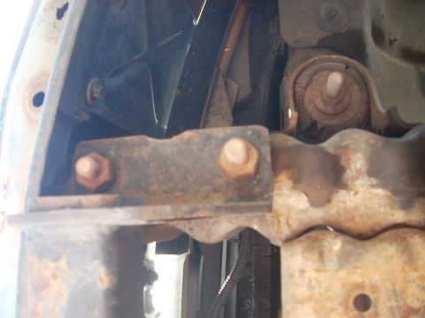 1992 Ford Bronco - Close-up view of a rusted metal bracket and bolts, likely from a vehicle's suspension or frame.