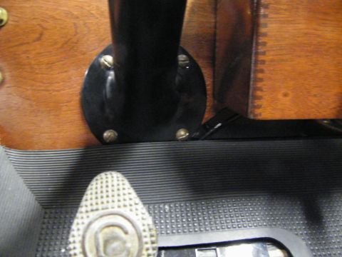 1912 Ford Model T - Close-up of the interior floorboard and dashboard of a vintage vehicle, showing pedals and wooden trim.