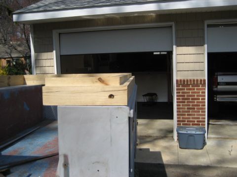 1996 Ford Bronco - A truck is parked in front of a garage with its bed loaded with materials.