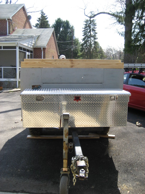 1996 Ford Bronco - A trailer is parked in front of a house, with a red car visible to the right.