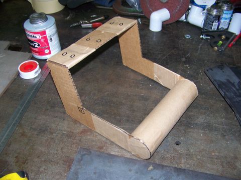 2001 Dodge 1500 - A homemade jig made of cardboard sits on a workbench next to various tools and supplies.