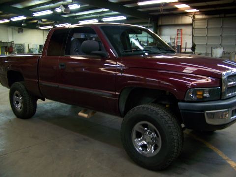 2001 Dodge 1500 - Maroon 2001 Dodge 1500 pickup truck in a workshop setting.