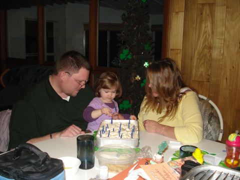 2000 Ford Crown Victoria - A family gathers around a table to celebrate with a cake, with a festive tree in the background.