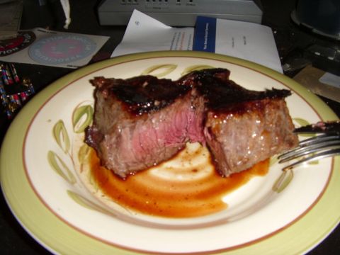 1978 Ford Bronco - A juicy steak is presented on a decorative plate, accompanied by a fork and some documents.