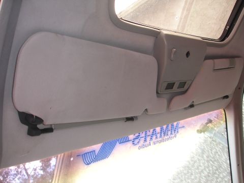 1989 Ford Taurus - The interior of a 1989 Ford Taurus shows the sun visors and overhead console, with a partial view of a window sticker.