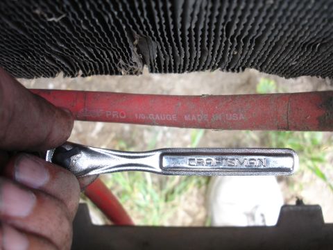 1989 Ford Taurus - A Craftsman wrench is shown near a radiator and a red hose marked "1/0 GAUGE MADE IN USA".