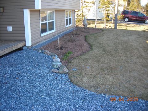 1984 Ford Bronco - A red minivan is parked on a driveway next to a house. The image also shows a gravel path and a lawn.