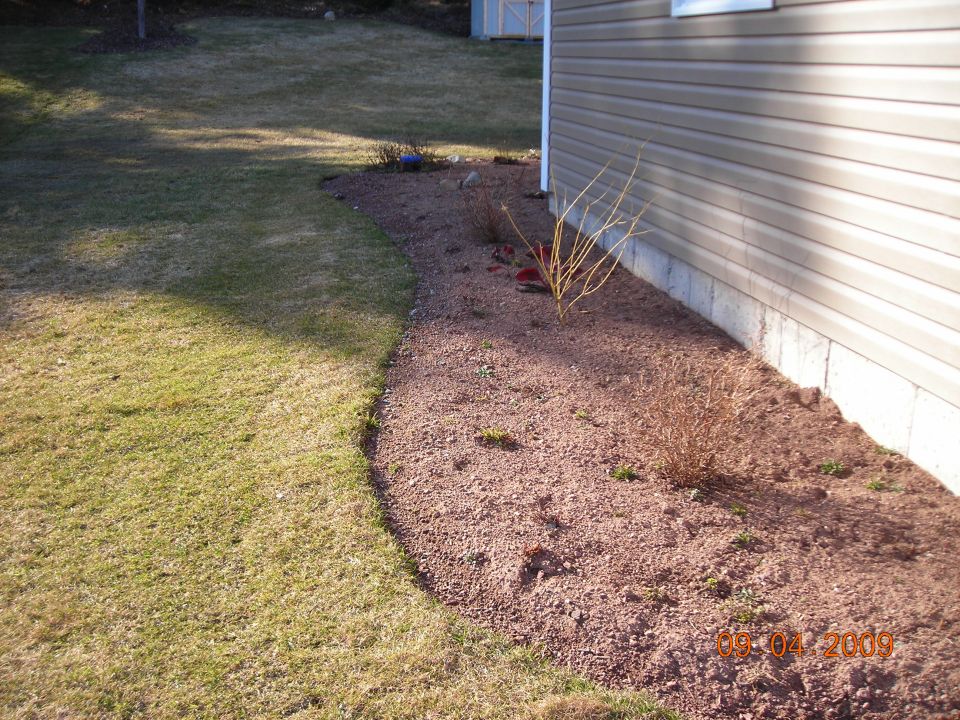 House siding, lawn, and gravel landscaping with a date stamp of 08-04-2009