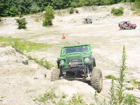 1992 Ford Bronco - Multiple off-road vehicles navigate a rocky, outdoor course.