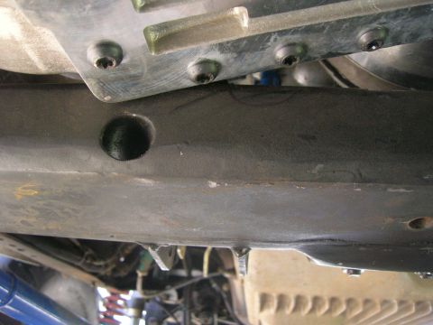 1996 Ford Bronco - Close-up view of the underside of a vehicle, showing mechanical parts and frame structure.