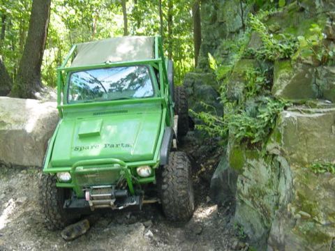 1992 Ford Bronco - This green off-road vehicle navigates a rocky trail, with "Spare Parts" visible on its hood.