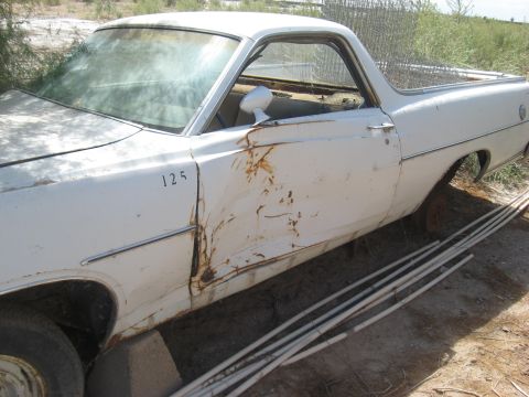 1973 Ford Ranchero - This 1973 Ford Ranchero shows significant rust and damage on its side, with the number '125' visible on the fender.