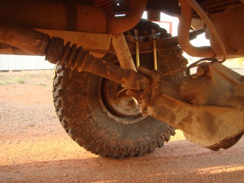 1992 Ford Bronco - Undercarriage view of a vehicle's rear axle and suspension components, with a large tire in frame.