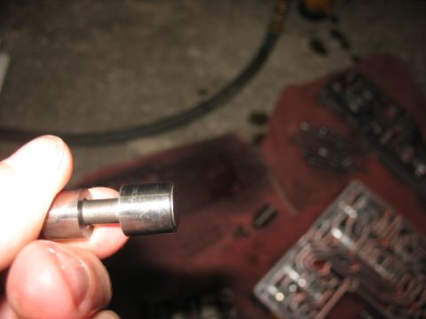 1995 Ford C-350 (Centurion Conversions) - Close-up of a transmission part being held, with a valve body visible in the background.