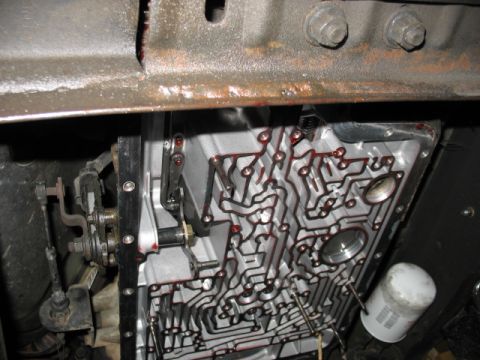 1995 Ford C-350 (Centurion Conversions) - Close-up of a transmission valve body, showing fluid channels and an oil filter.
