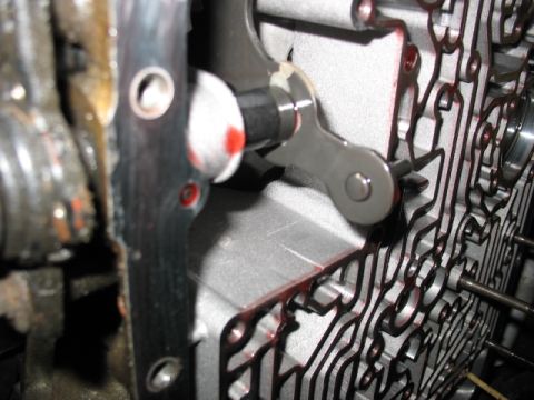 1995 Ford C-350 (Centurion Conversions) - Close-up view of a transmission valve body, showing internal components and red fluid.