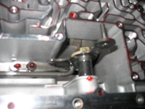 1995 Ford C-350 (Centurion Conversions) - Close-up view of a transmission valve body, showing internal components and red fluid residue.