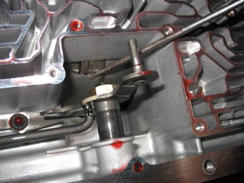 1995 Ford C-350 (Centurion Conversions) - Internal view of an automatic transmission, highlighting the shift linkage and metal casing with traces of transmission fluid.