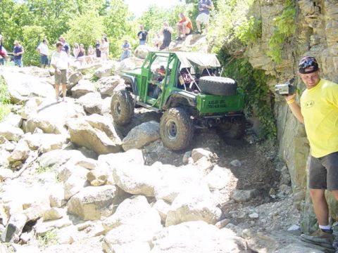 1992 Ford Bronco - A man films an off-road vehicle as it navigates a challenging rocky terrain with onlookers present.