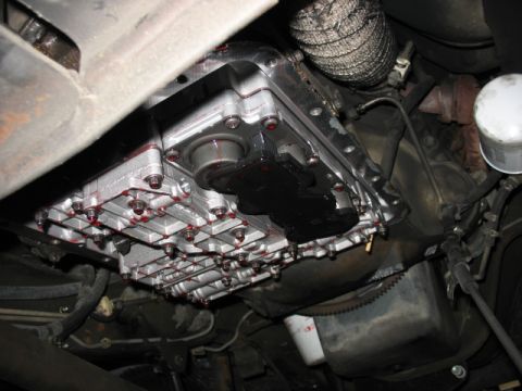 1995 Ford C-350 (Centurion Conversions) - Transmission pan showing fluid leaks around the bolts and gasket.