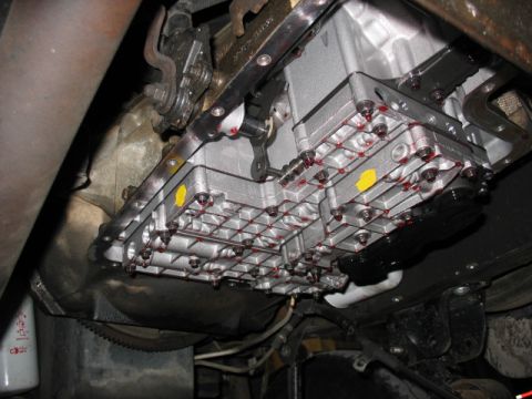 1995 Ford C-350 (Centurion Conversions) - Close-up view of a vehicle's transmission pan, showing the bolts and fluid seepage.