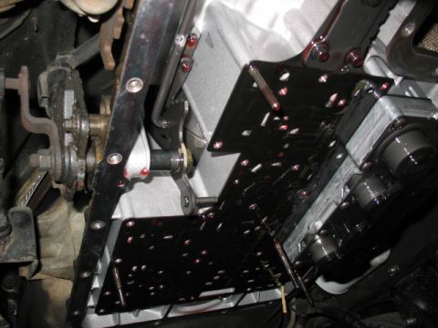 1995 Ford C-350 (Centurion Conversions) - Underside view of a vehicle's transmission pan and valve body, showing mechanical components and fluid.